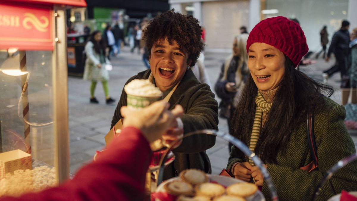 Adults buying hot drink in winter in Newcastle UK.