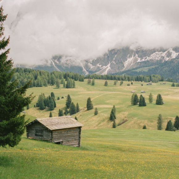 A traditional mountain hut set within the Alpe di Siusi in the Dolomites, Italy, linking to BA High Life site. 