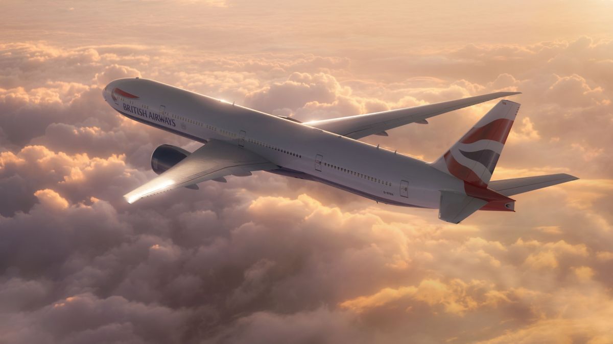 Boeing 777-300 flying above the clouds in the sunlight.