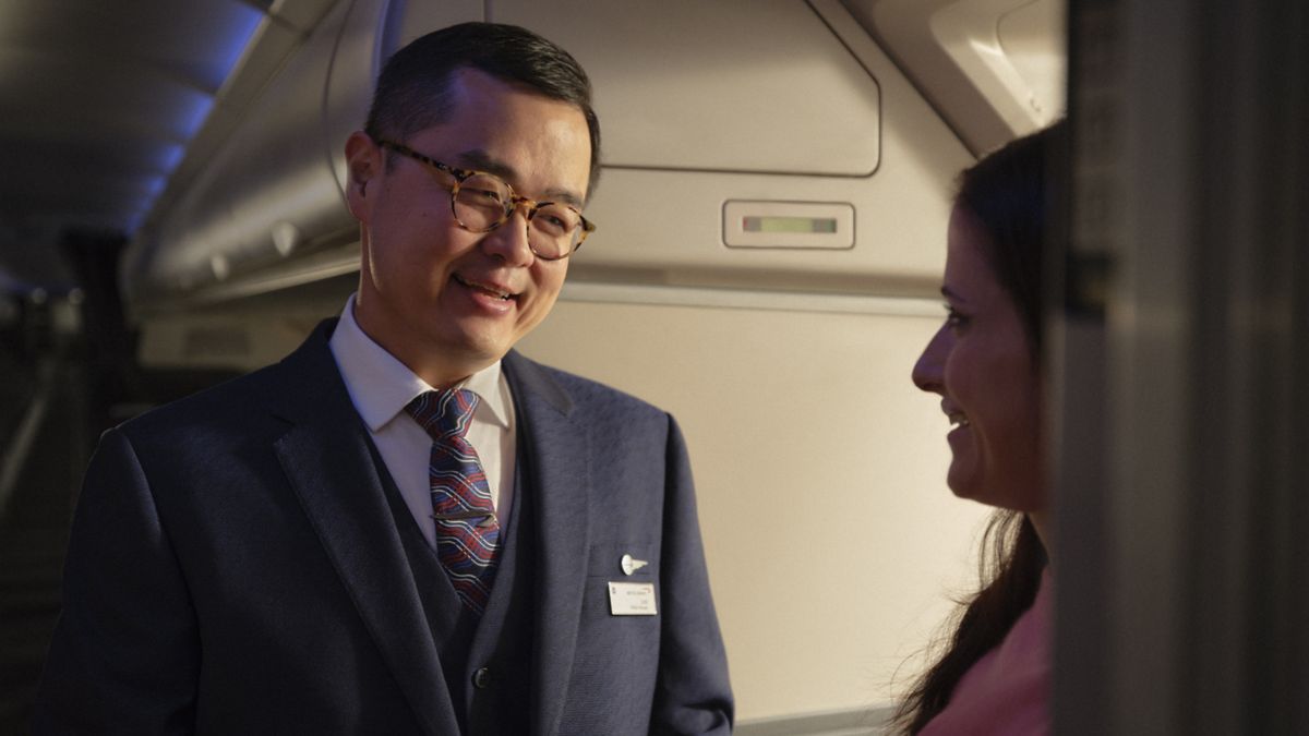 British Airways cabin crew member welcoming a customer onboard.