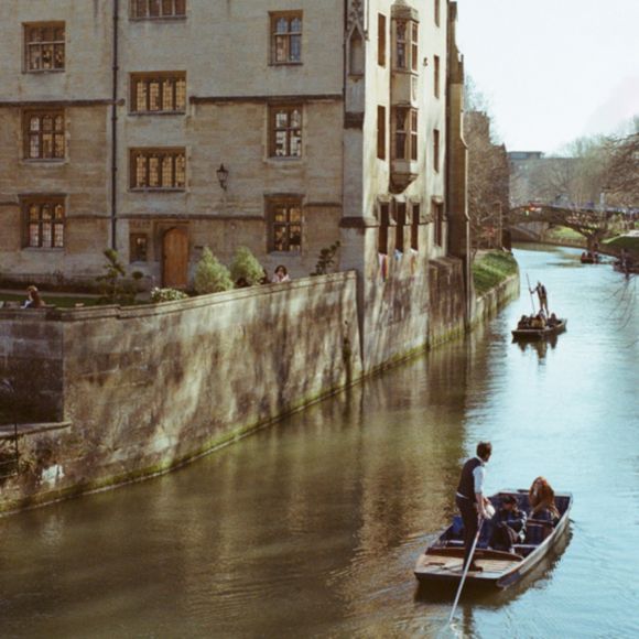 Two punts gliding along the river Cam past the University of Cambridge colleges, linking to BA High Life website.