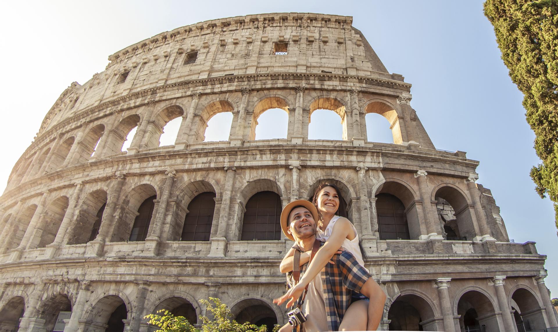 A couple embrace outside the Roman Colosseum.