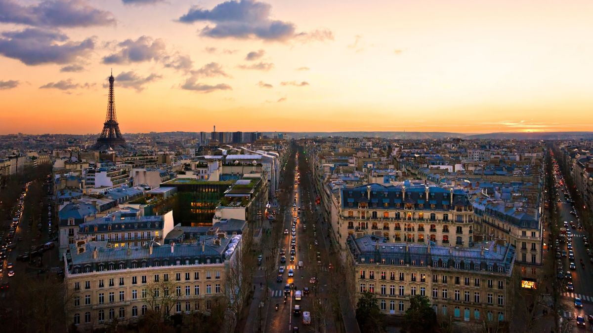 View of the Eiffel tower and cityscape at sunset in Paris.