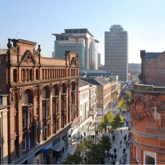 Elevated view of a pedestrianised street in Glasgow with a mix of old and new buildings, linking to BA High Life site.