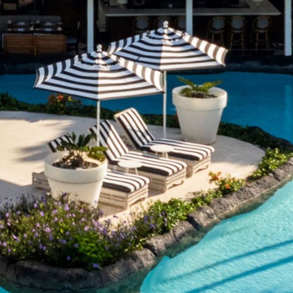 Loungers by the swimming pool at Colony Club resort in Barbados, linking to BA High Life site.