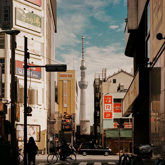 Street in Tokyo, with the Skytree in the distance, linking to BA High Life site.