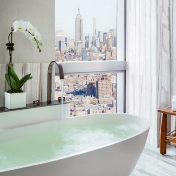A bathtub with a view of New York City, linking to www.bahighlife.com.