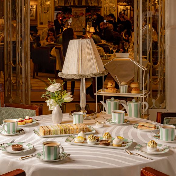 An afternoon tea spread with tea, sandwiches and little cakes served in Claridge’s Reading Room, linking to BA High Life website.