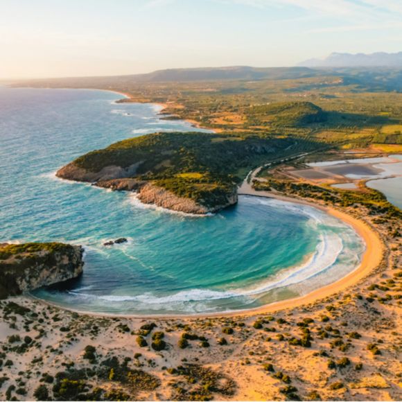 The circular bay of Voidokilia in the Peloponnese, linking to BA High Life website.