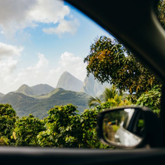 A view of the Pitons in St Lucia as seen from a car window, linking to www.bahighlife.com.