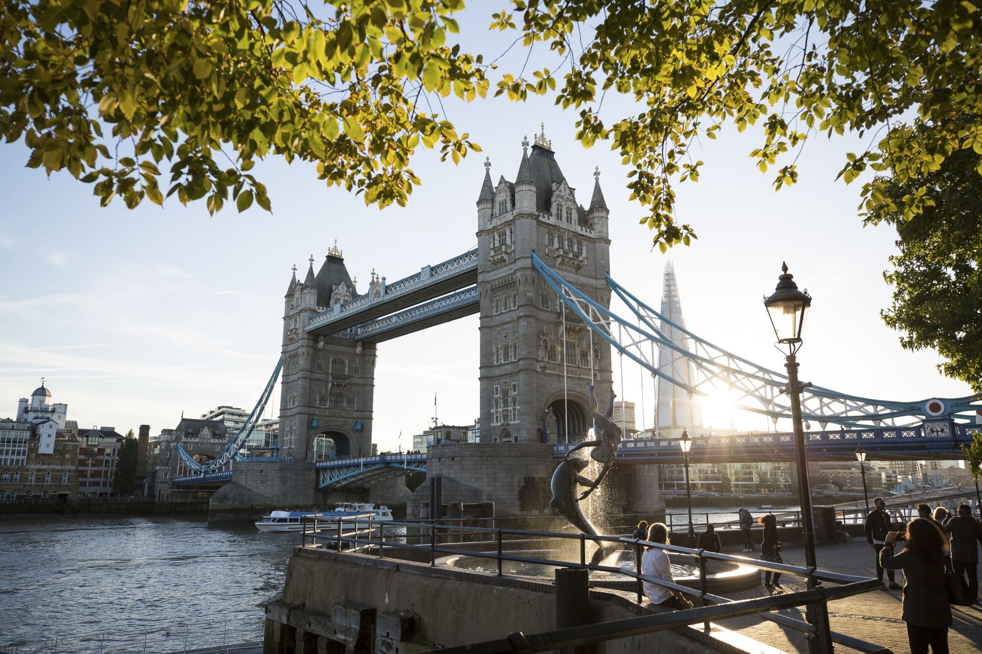 View of Tower Bridge and the Dolpin statue at sunset in London.