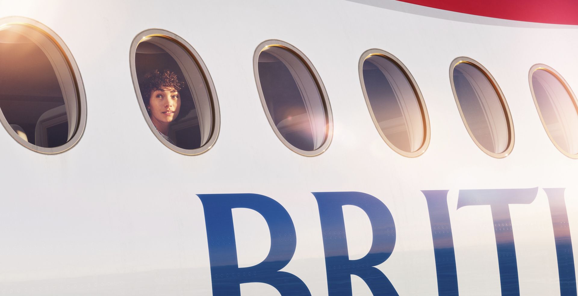 British Airways customer looking out through a aircraft window.