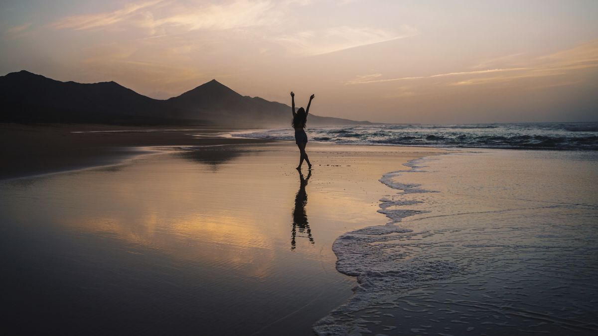 Young adult enjoying sunset alone at the beach in Fuerteventura.